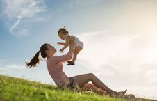 A Mom Adoring Her Child Sitting On The Grass, Enjoying A Fun Summer Day Together. Parenthood Royalty Free Stock Image