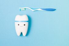 Happy Tooth And Plastic Toothbrush With A Blue Pen On A Blue Background Royalty Free Stock Photography