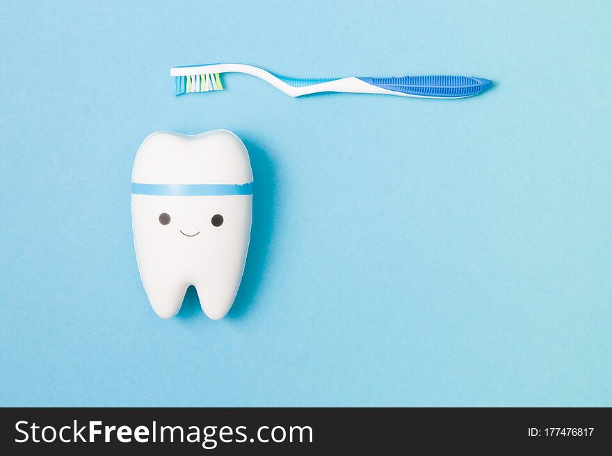 Happy Tooth And Plastic Toothbrush With A Blue Pen On A Blue Background