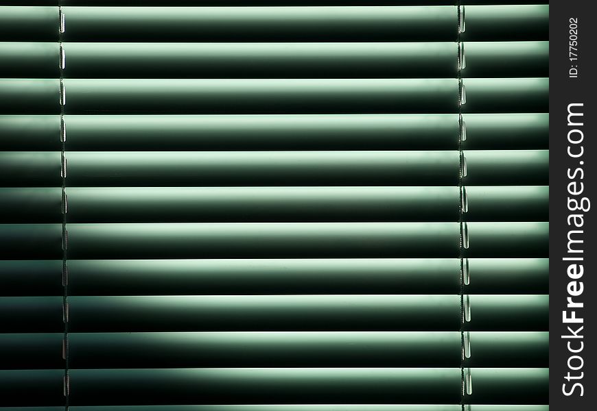 Half-closed louvers stopping morning sunshine through a window