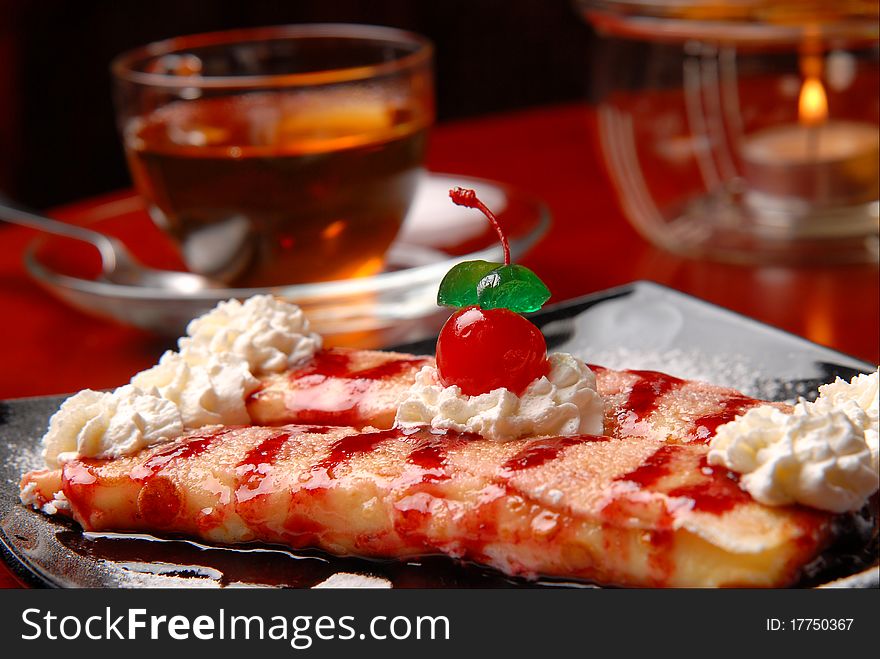 Dessert to tea pancakes with a cherry and a cream