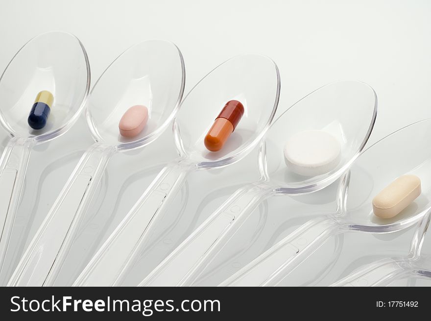 Pills in clear plastic spoons