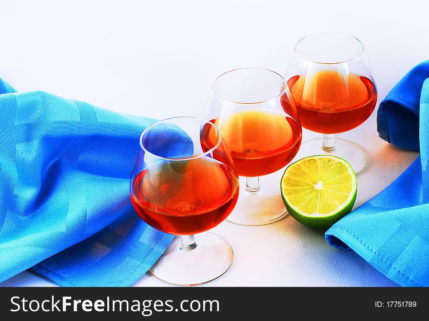 Three glasses of brandy on white background