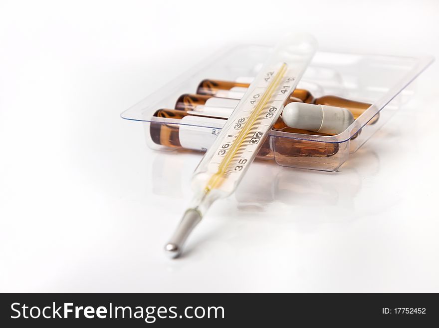 Thermometer pill and ampoules isolated in white