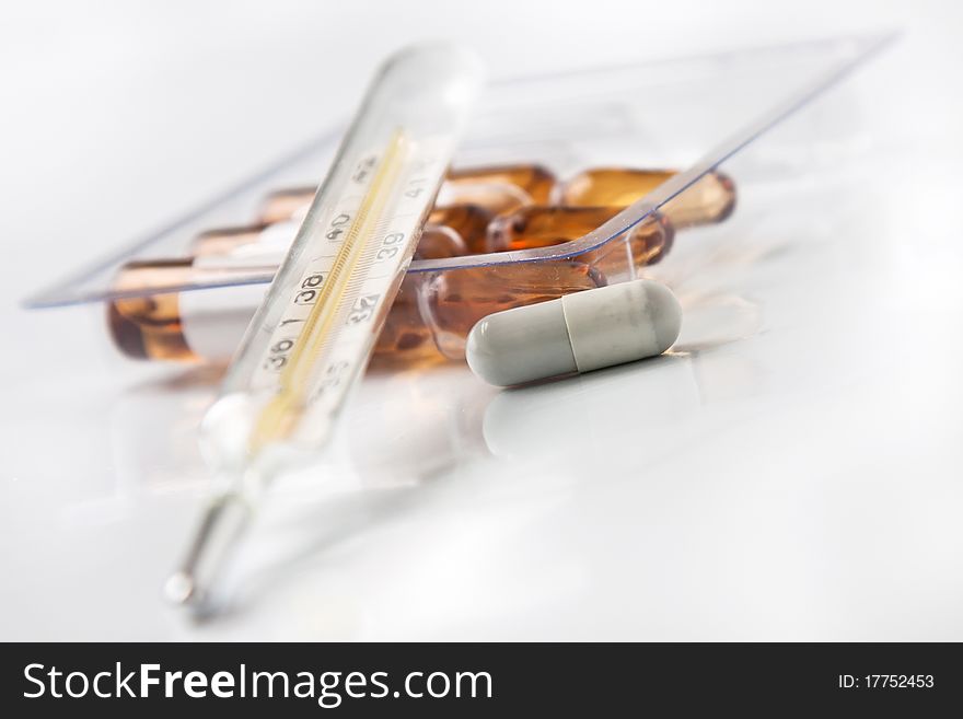 Thermometer pill and ampoules isolated in white