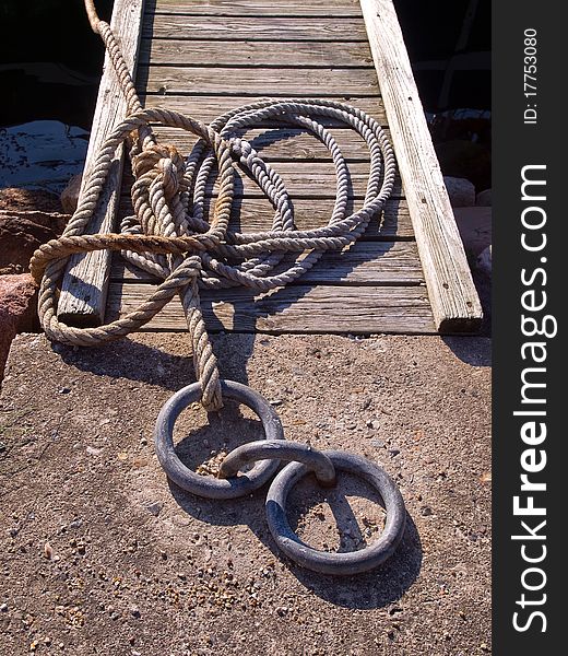Classical anchoring point made of cast iron in a port marina / nautical background horizontal image. Classical anchoring point made of cast iron in a port marina / nautical background horizontal image