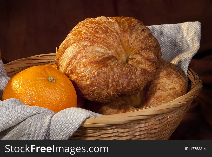 Freshly made breads croissant served at breakfast   with orange fruit. Freshly made breads croissant served at breakfast   with orange fruit