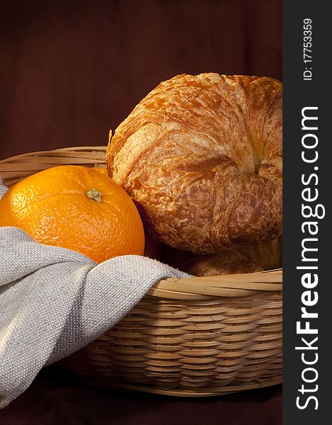 Freshly made breads croissant served at breakfast with orange fruit. Freshly made breads croissant served at breakfast with orange fruit