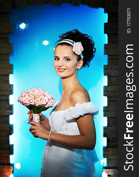 Portrait beautiful bride with bouquet of flowers on blue background in wedding day. Portrait beautiful bride with bouquet of flowers on blue background in wedding day