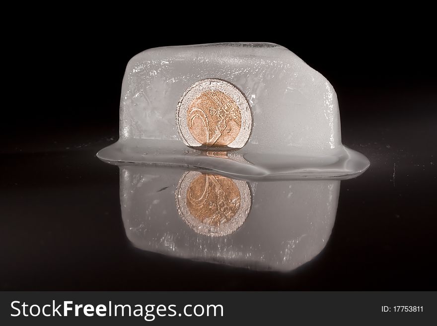 Frozen two euro coin on black isolated background