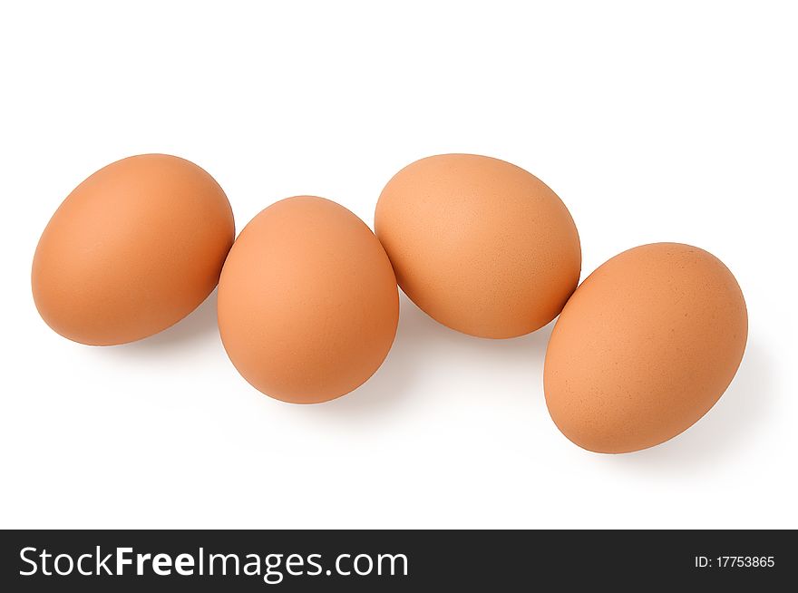 Four brown eggs on a white background