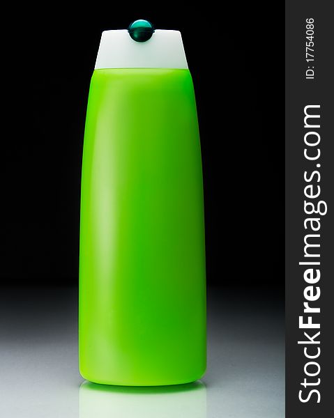 Green shampoo bottle with reflection