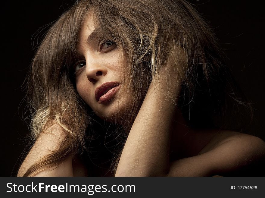 Portrait of pretty young woman isolated on dark background