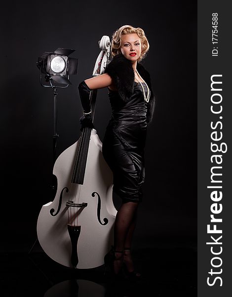 Young woman in fashionable dress with double bass. Young woman in fashionable dress with double bass