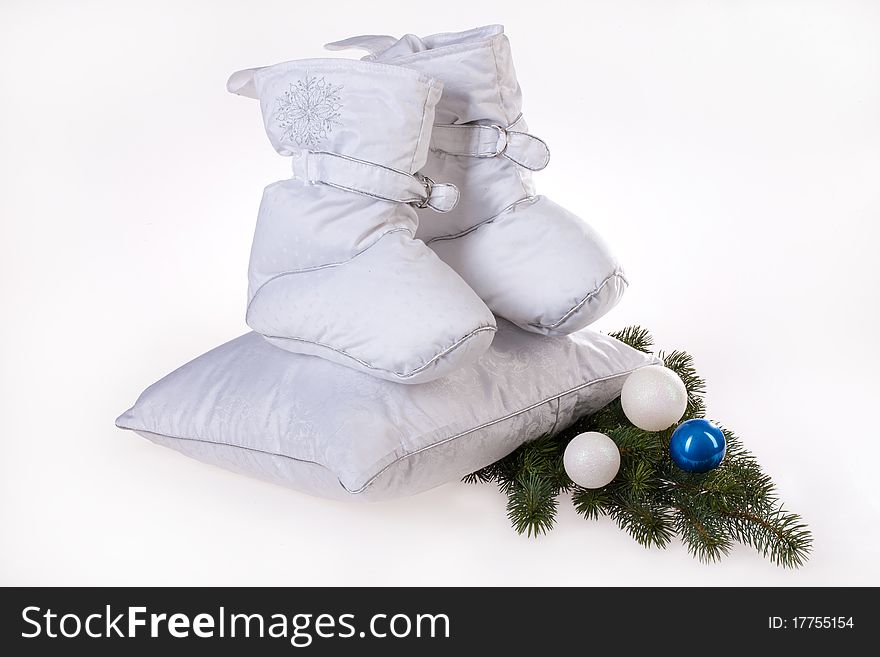 Shoes and pillows made of down with a fie branch on isolated background. Shoes and pillows made of down with a fie branch on isolated background