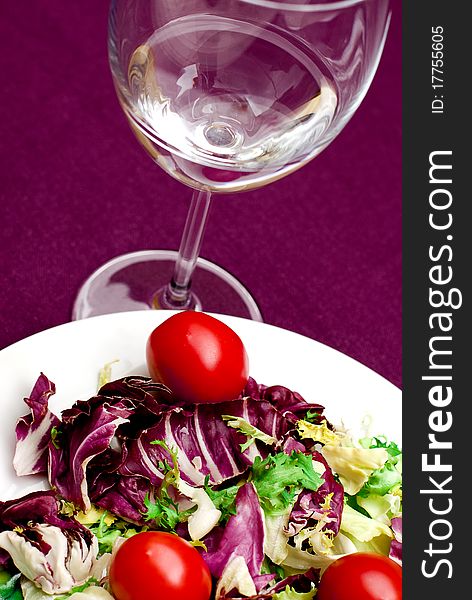 Salad and glass of water in violet