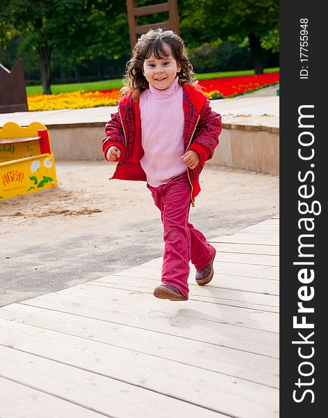 Little girl running in playground in a park