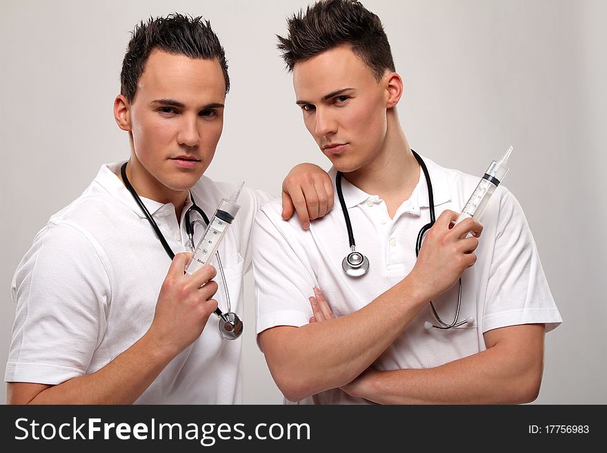 Male twin doctors posing with some medical stuff