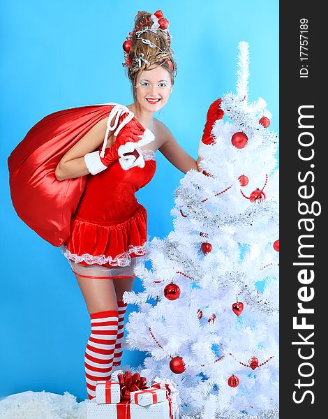 Beautiful young woman in Santa Claus clothes holding presents over Christmas background. Beautiful young woman in Santa Claus clothes holding presents over Christmas background.