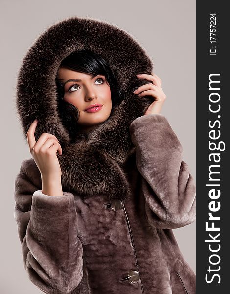 Young attractive woman in a fur coat on isolated background. Young attractive woman in a fur coat on isolated background