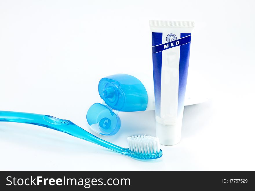 Tooth brush beside toothpaste on white background.