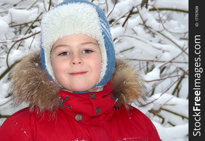 Portrait of a boy in winter clothing against the backdrop of snow