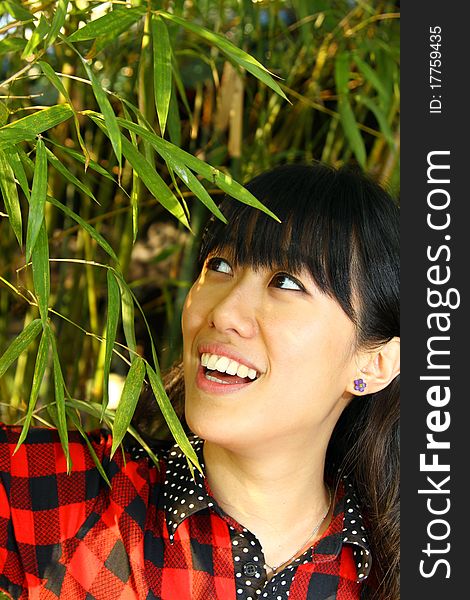 She is a Chinese, who smiles sweetly with bamboo background. She is a Chinese, who smiles sweetly with bamboo background