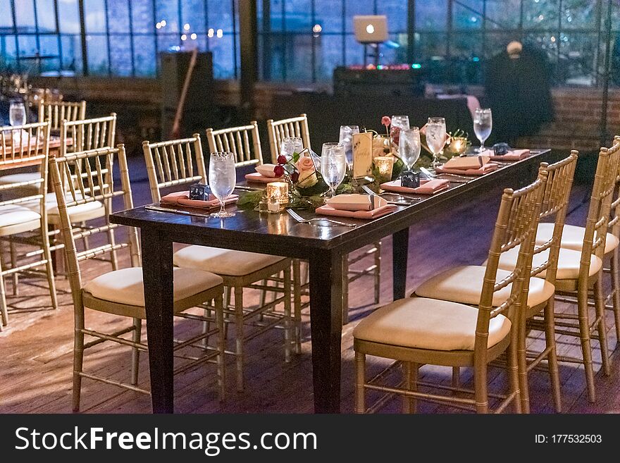 A high angle shot of a table with an elegant setting in the restaurant hall in the evening