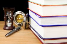 Pile Of Books, Pen And Hourglass On Black Stock Image