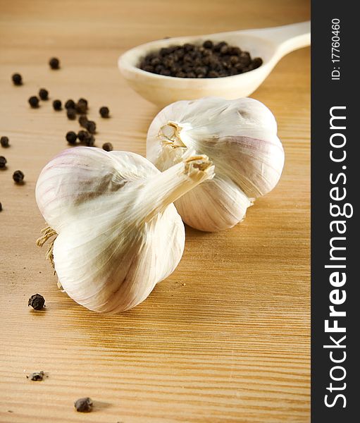 Garlic and pepper on wooden spoon