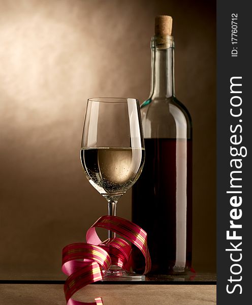 Bottle and glass of wine on a dark background