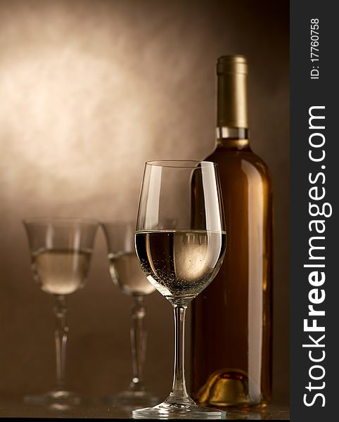 Bottle and glass of wine on a dark background. Bottle and glass of wine on a dark background