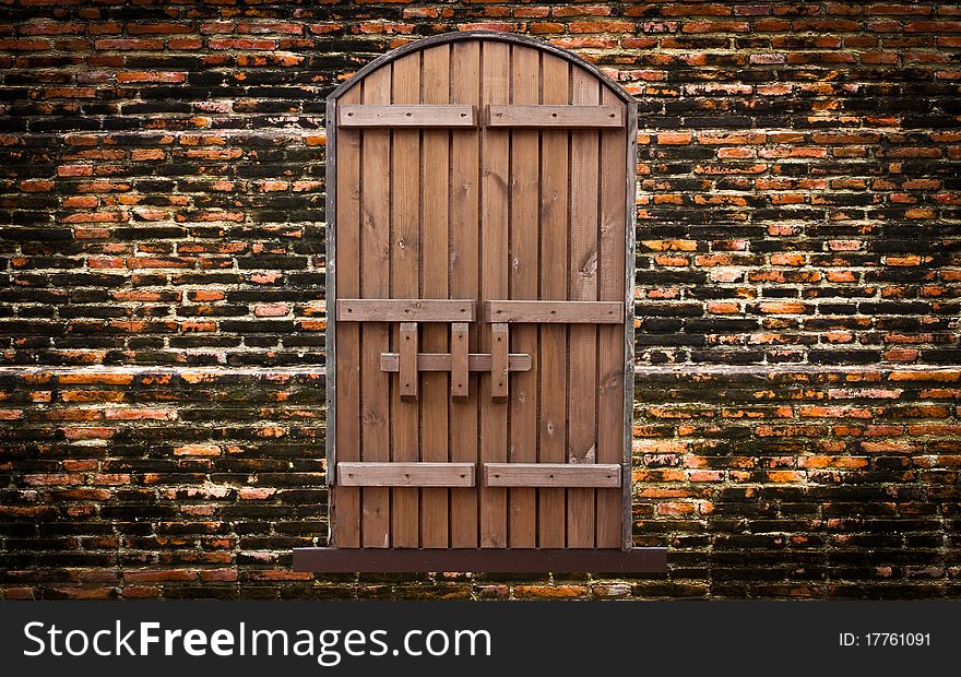 Wooden door on vintage brick wall