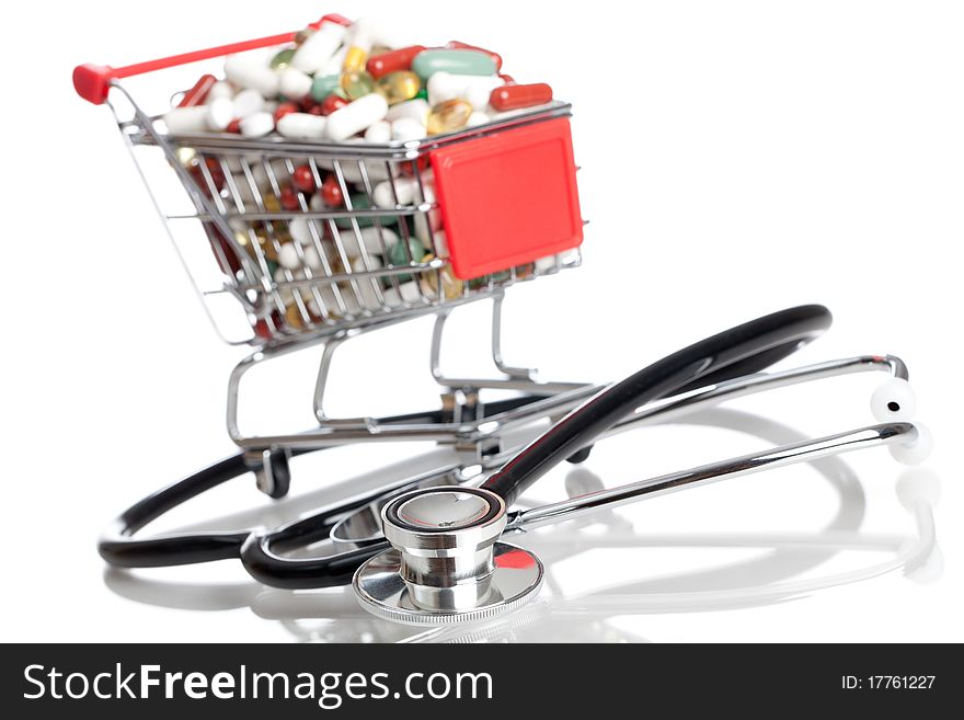 A shopping cart full of pills, capsules, medicine and a stethoscope - isolated on white. A shopping cart full of pills, capsules, medicine and a stethoscope - isolated on white