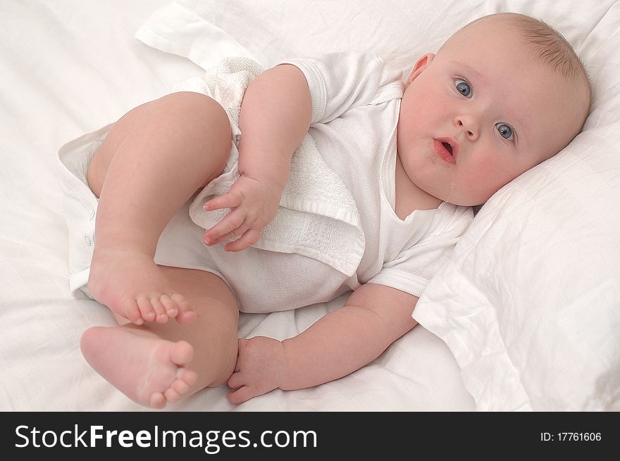 Baby boy lying on white sheets