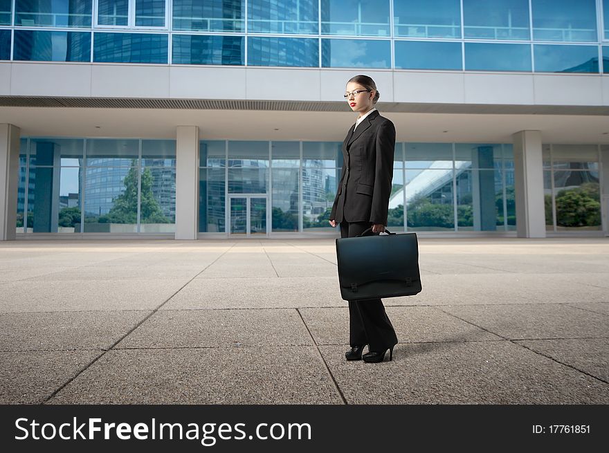Businesswoman standing in front of elegant office buildings. Businesswoman standing in front of elegant office buildings