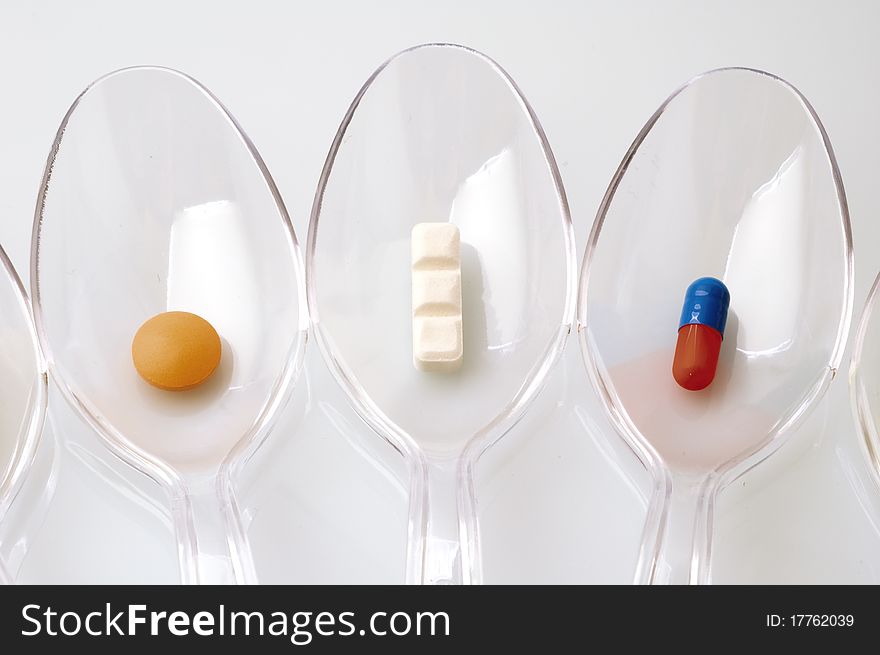 Pills in clear plastic spoons