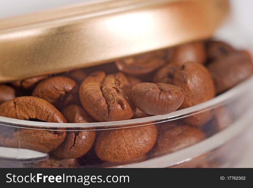 One jar roasted brown coffee beans close-up. One jar roasted brown coffee beans close-up.