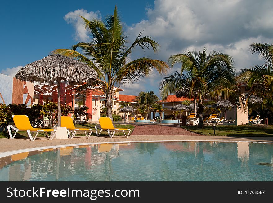 Pool, sun chairs and palm trees in an all inclusive hotel in the tropics. Pool, sun chairs and palm trees in an all inclusive hotel in the tropics