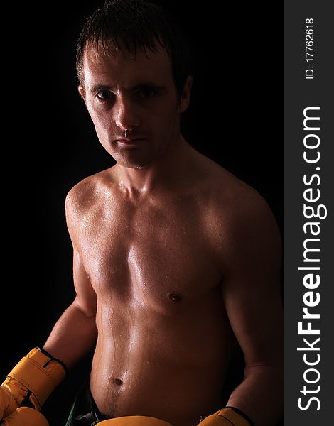 Model looking at the camera ready for fighting on black background. Model looking at the camera ready for fighting on black background