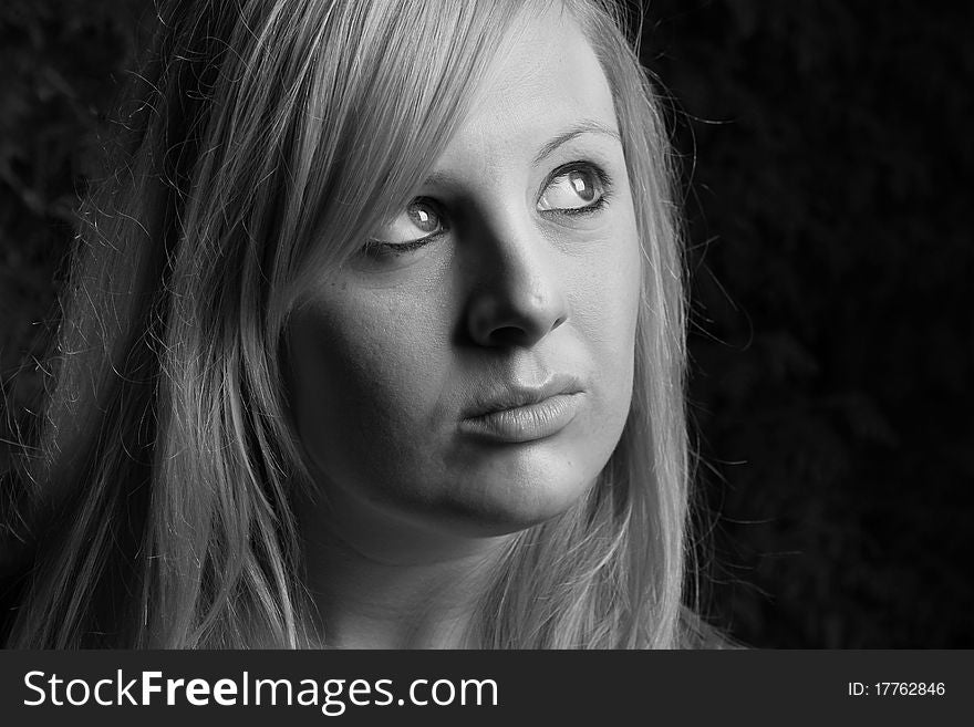 A young girl look up towards the light with black and white background. A young girl look up towards the light with black and white background