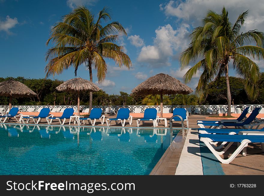 Pool, sun chairs and palm trees in an all inclusive hotel in the tropics. Pool, sun chairs and palm trees in an all inclusive hotel in the tropics