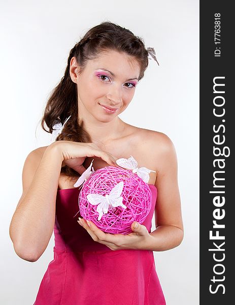 Portrait of young woman holding a pink sphere in her hands and butterflies in her hair. Portrait of young woman holding a pink sphere in her hands and butterflies in her hair