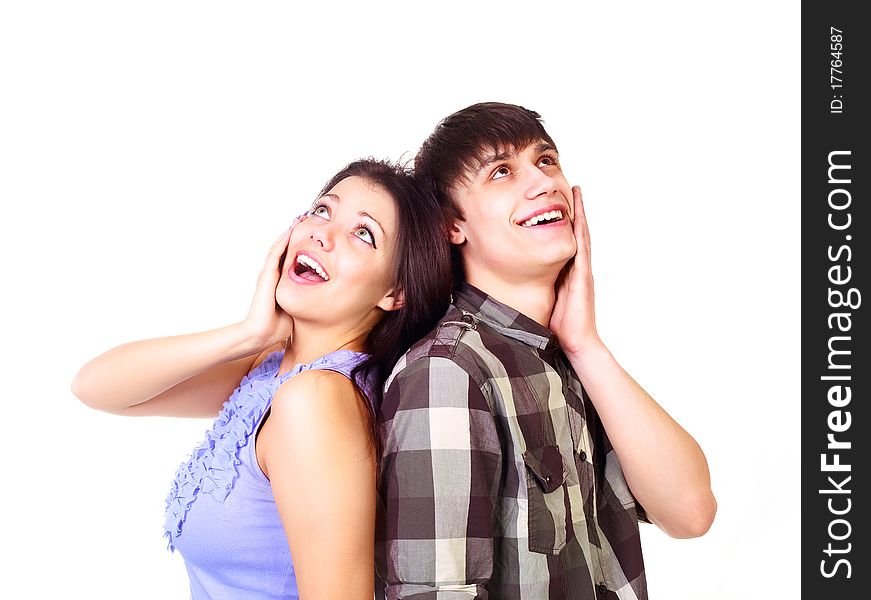 Beautiful surprised teenage couple looking up