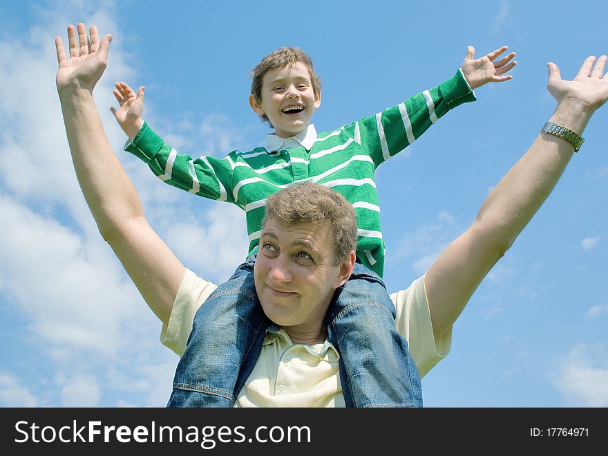 Father and his son against the blue sky