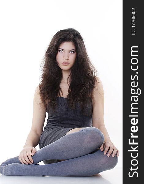 Young fashion model sitting on white background