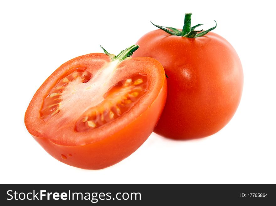 One whole and one cut tomato on a white background. One whole and one cut tomato on a white background