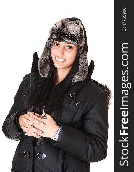 A pretty woman in a winter coat and an fur cap standing in the studio smiling into the camera, over white background. A pretty woman in a winter coat and an fur cap standing in the studio smiling into the camera, over white background.