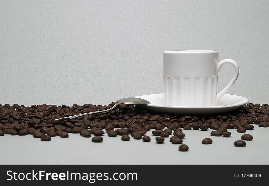 A cup of coffee and beans isolated over white background