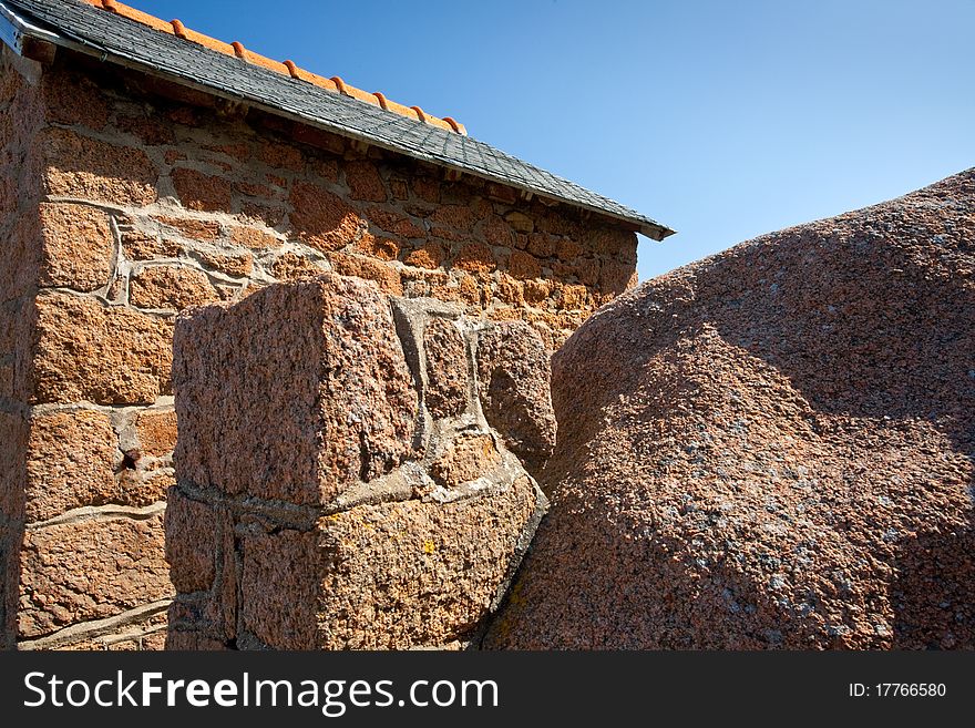 Wall of traditional stone Breton house made from granite rock